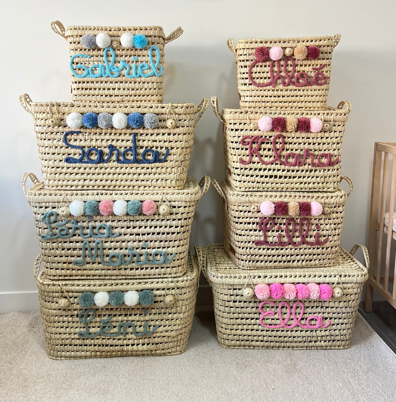 Malles de rangement en osier personnalisées de différentes tailles, avec prénoms en tricotin et pompons colorés