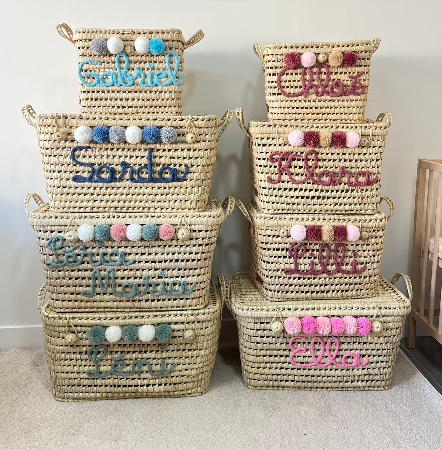 Malles de rangement en osier personnalisées de différentes tailles, avec prénoms en tricotin et pompons colorés