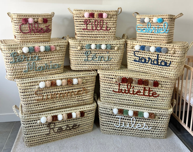 Collection de coffres à jouets personnalisés en osier, différentes tailles avec prénoms en tricotin et pompons multicolores