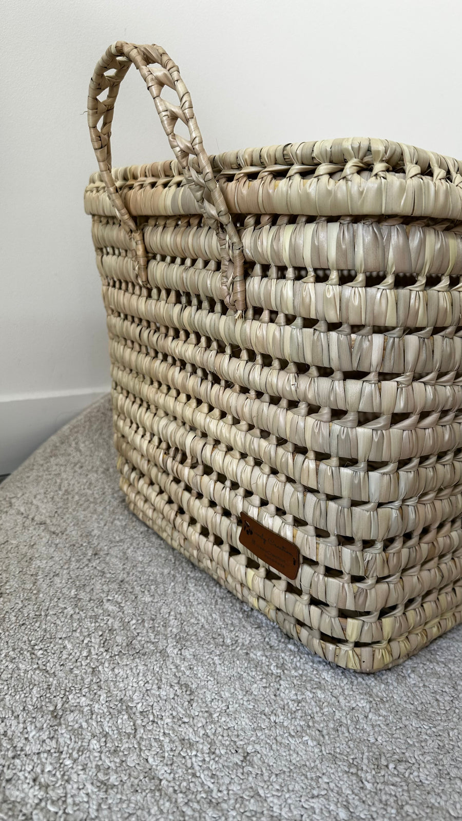 Détail du coin et des finitions d'une malle artisanale en osier