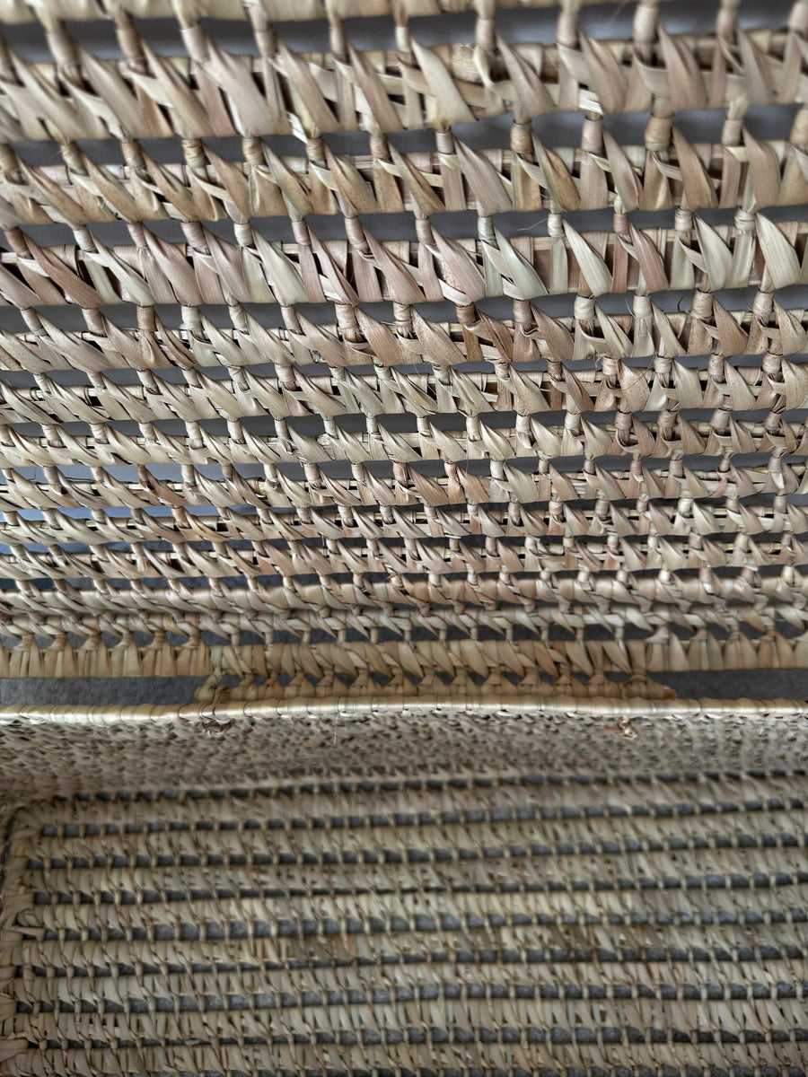 Gros plan du tressage artisanal en feuilles de palmier et osier