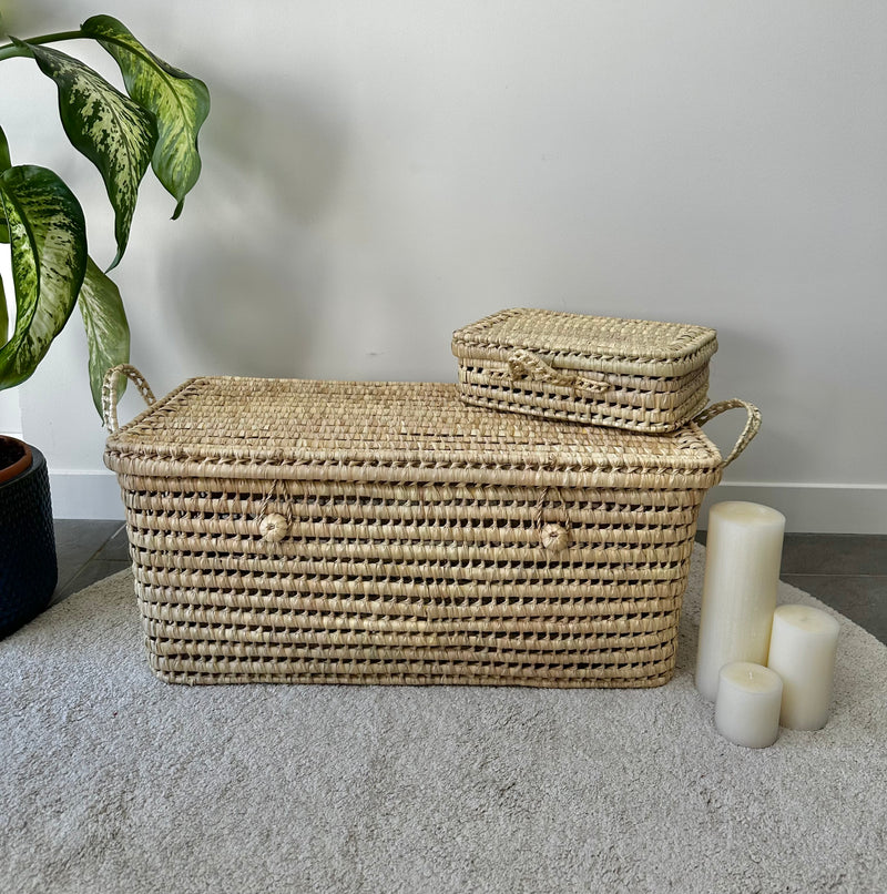 Grande malle en feuilles de palmier avec petit panier assorti posé sur le couvercle